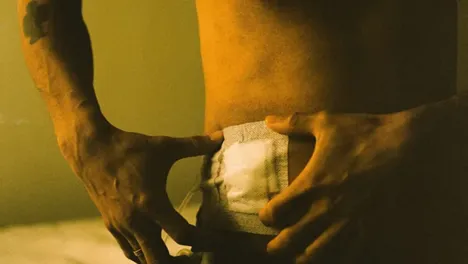 Man putting bandage on stomach with two hands
