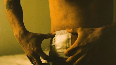 Man putting bandage on stomach with two hands