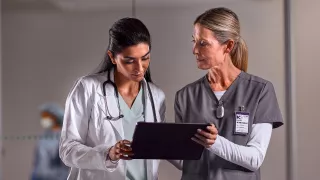 Healthcare professionals looking at a tablet