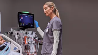 Doctor checking patient information on screen in hospital